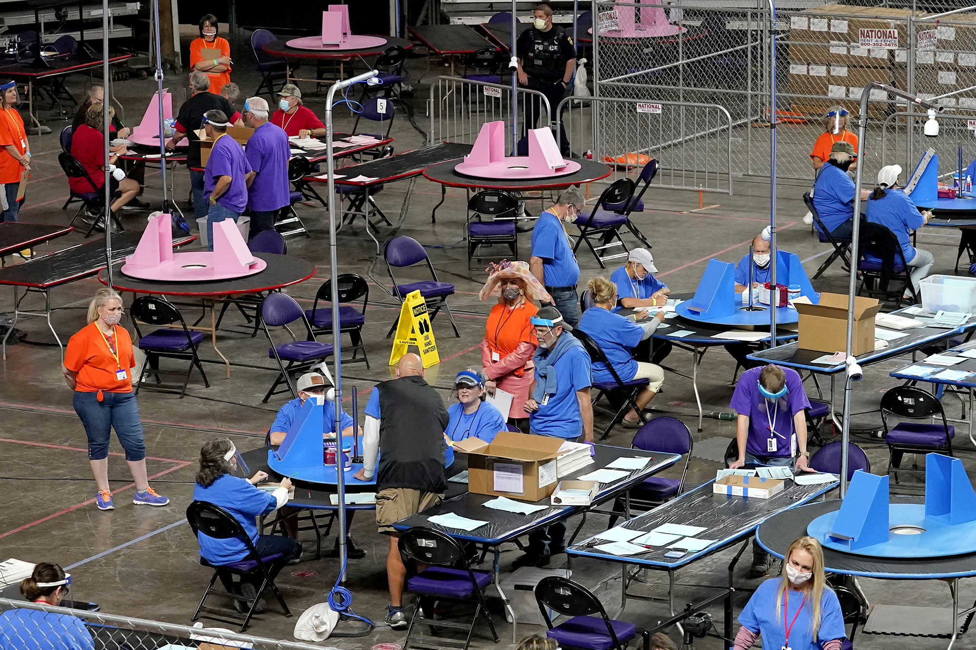 A hall with people counting ballots