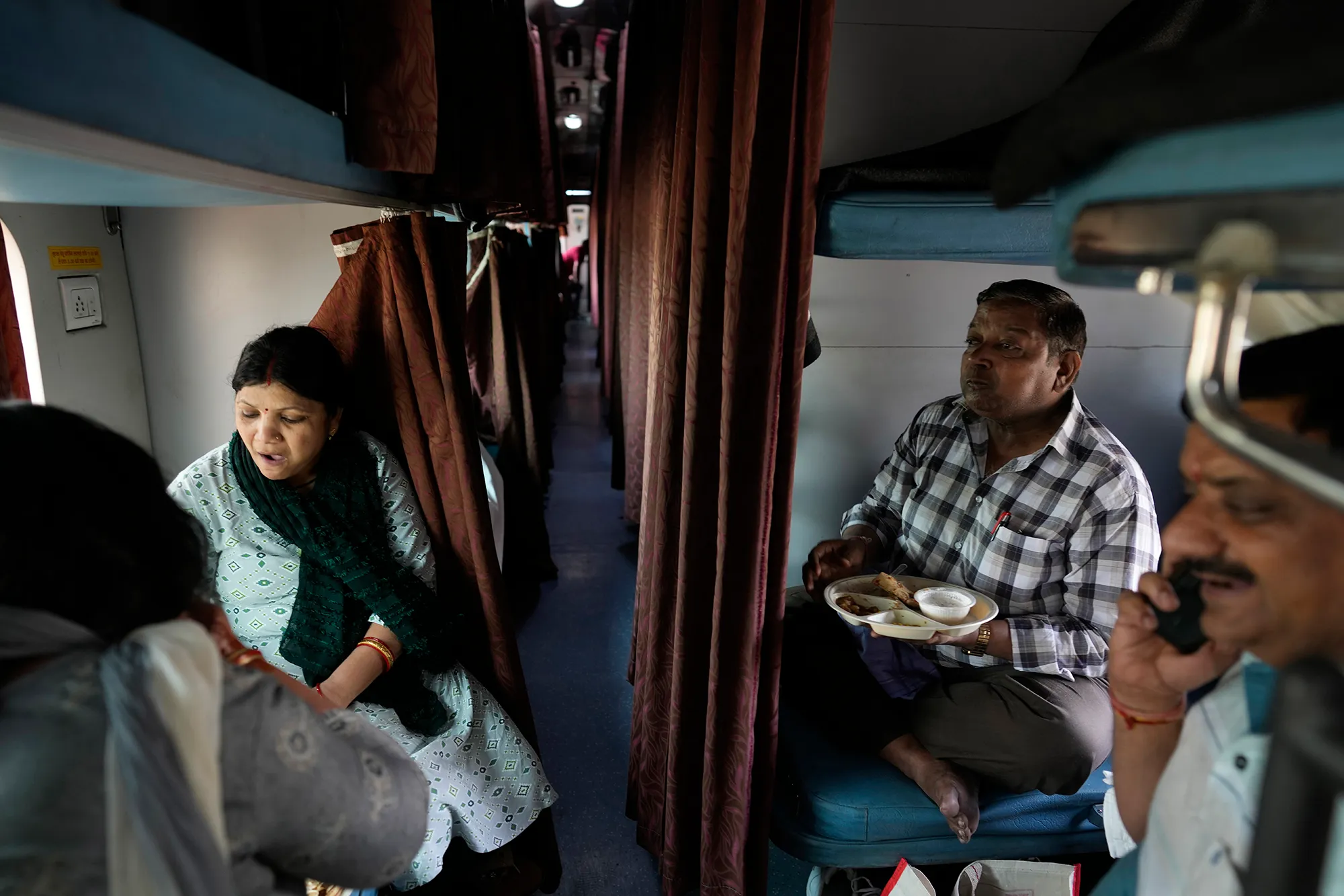 A group of people in an Indian train carriage.