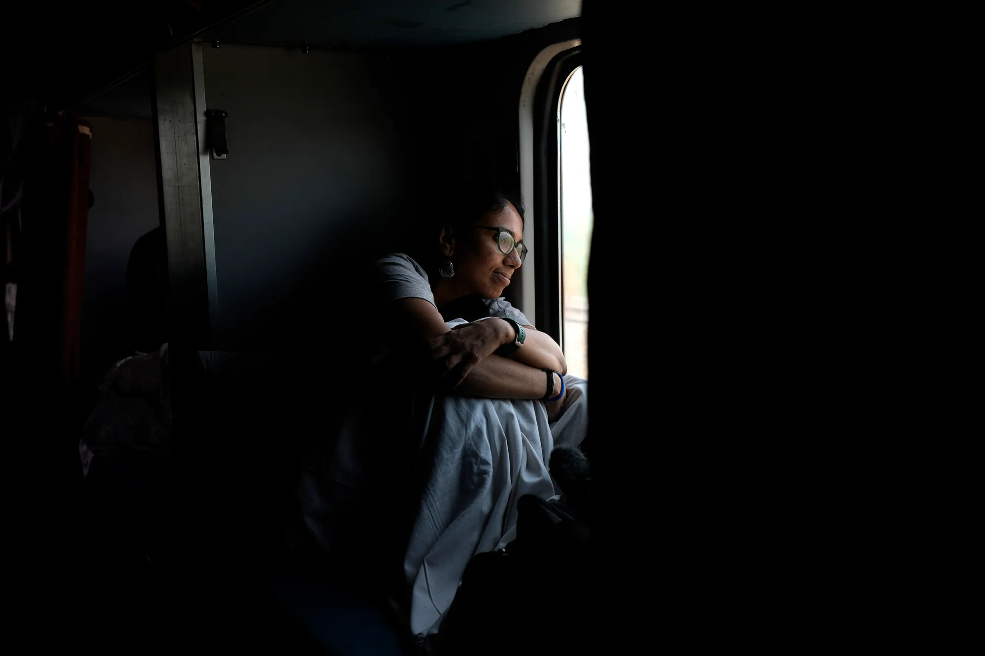An Indian woman looking outside a train window
