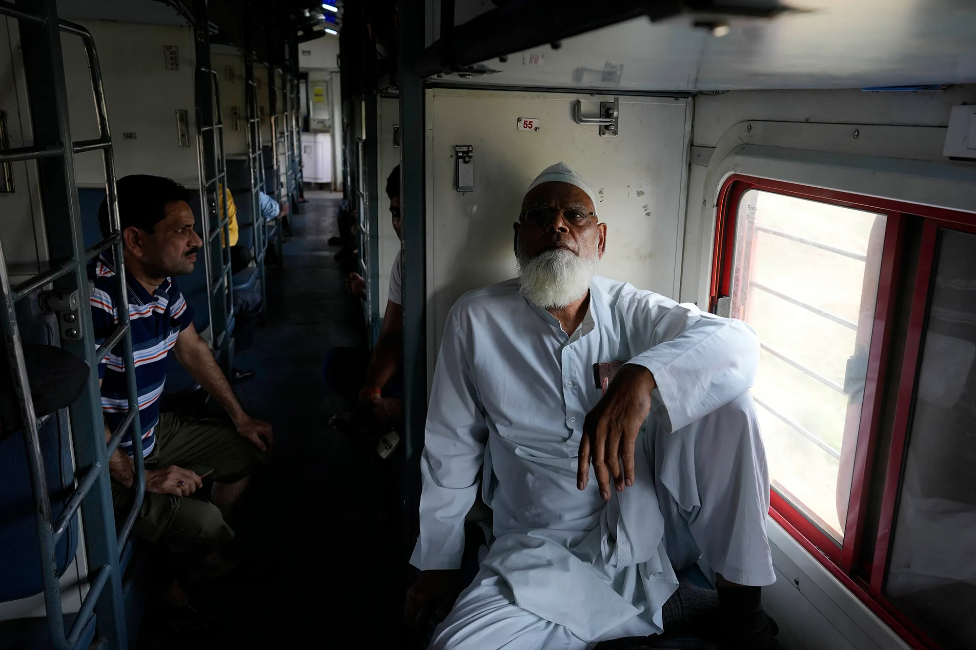 A man sitting on bench on an Indian train