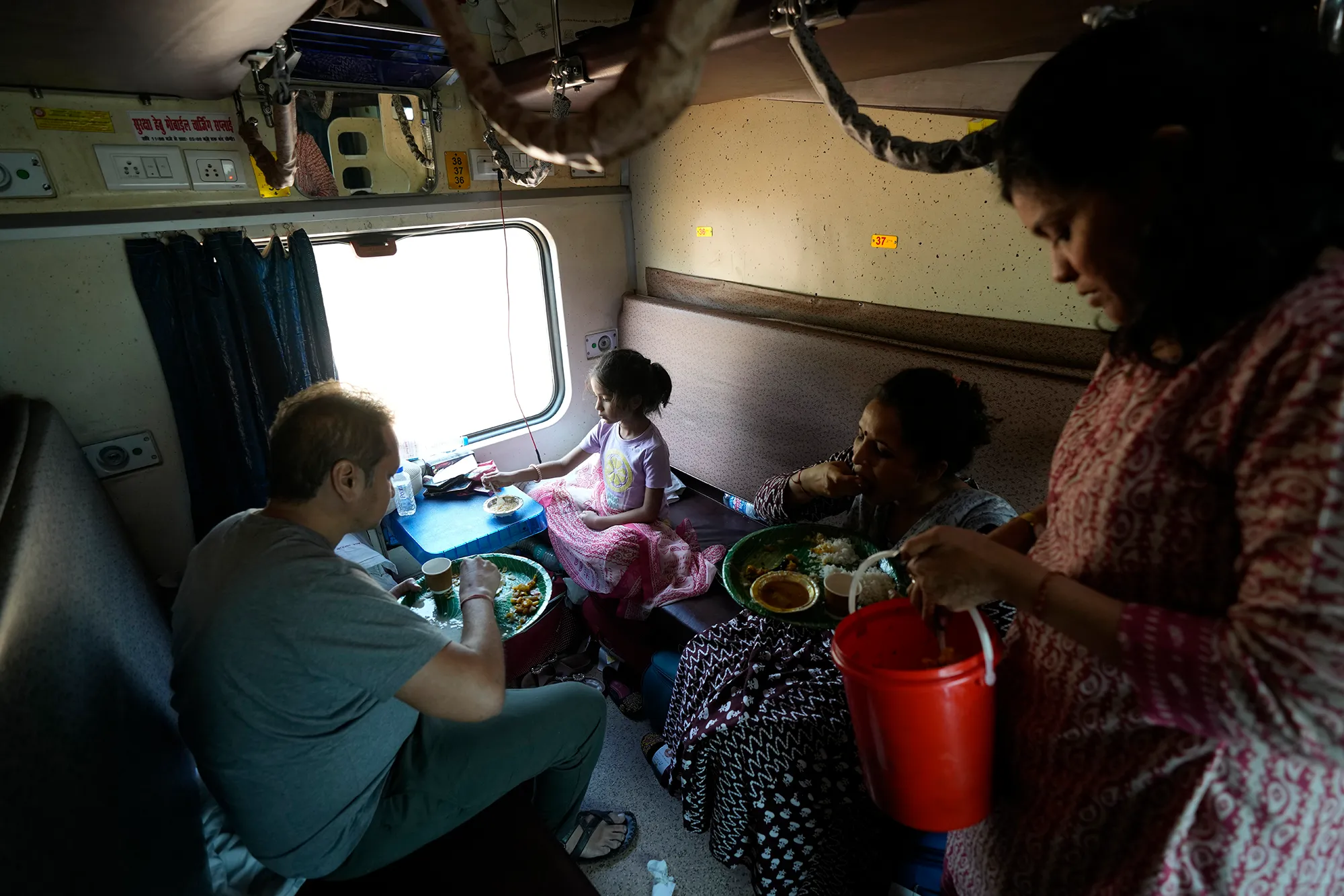 A group of people in an Indian train carriage.