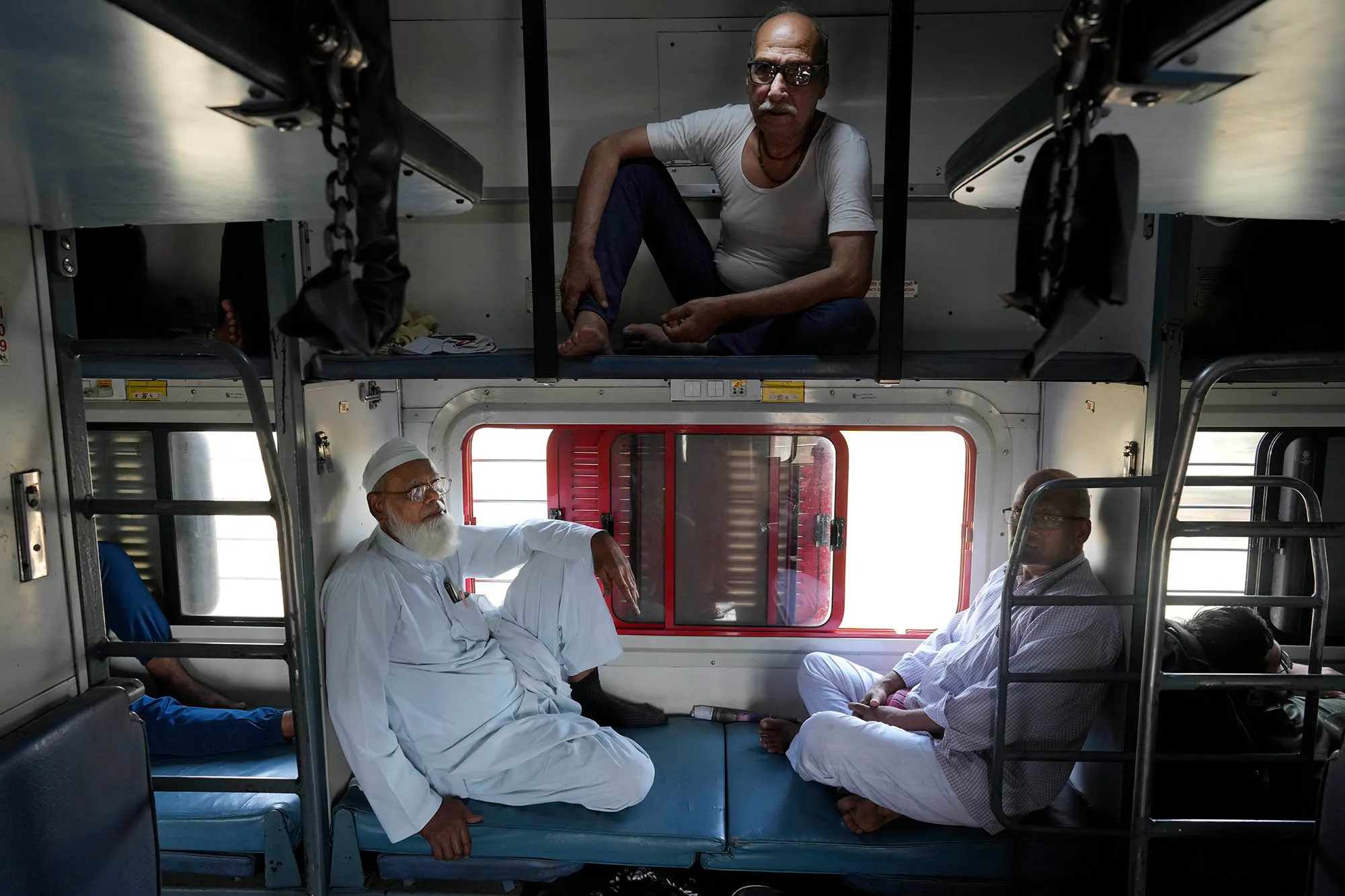 3 men sitting in a train carriage in India