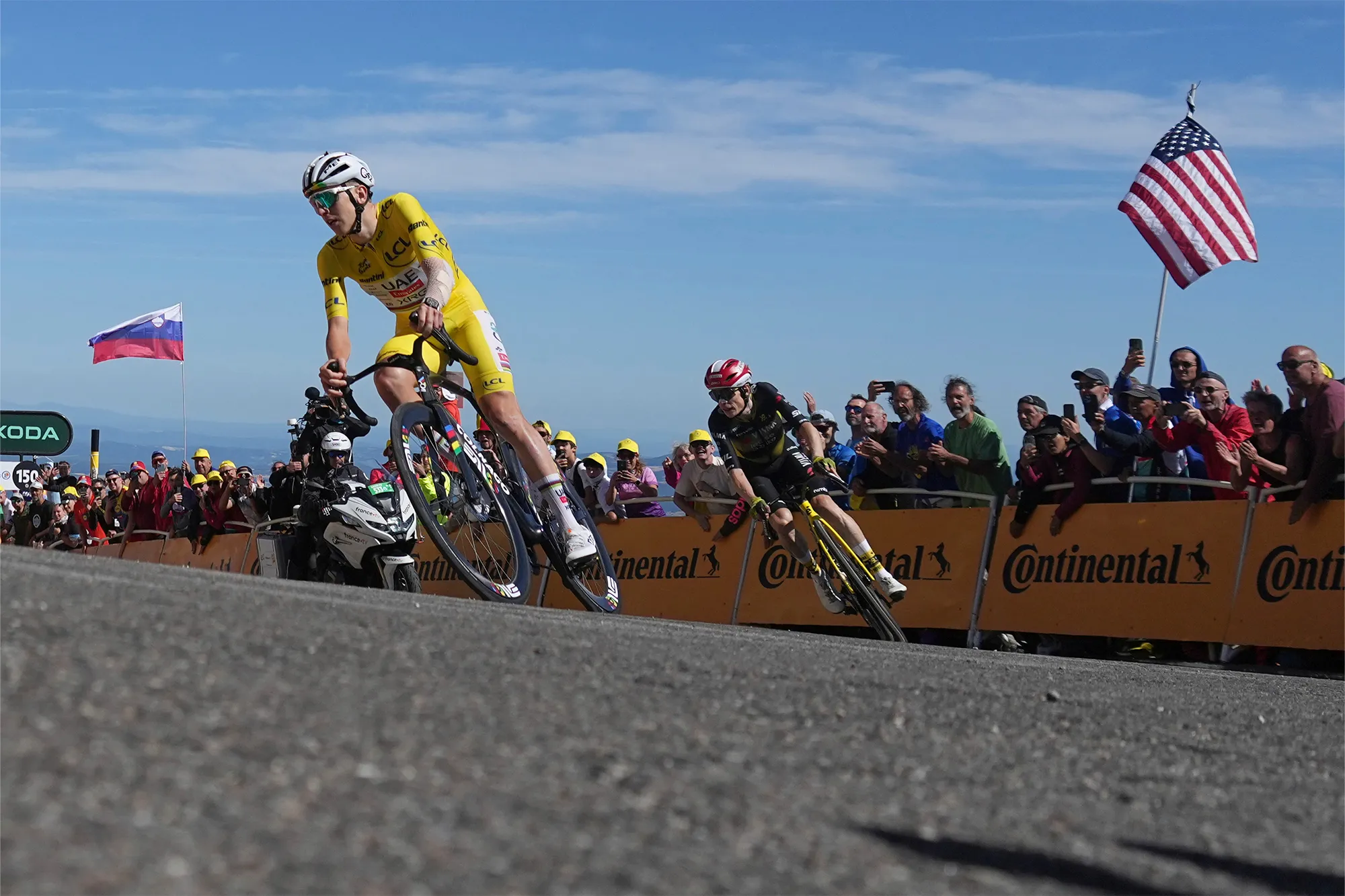 Slovenia's Tadej Pogacar, wearing the overall leader's yellow jersey, and Denmark's Jonas Vingegaard cycling on a turn