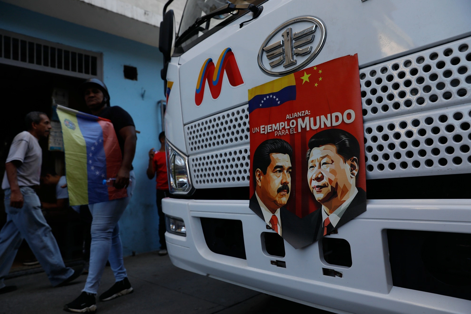A photo of a bus banner with images of Nicolás Maduro and Xi Jinping at a Caracas rally